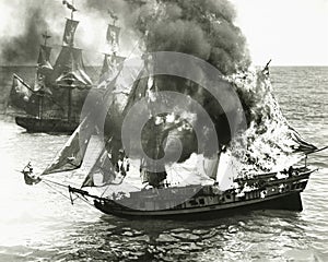 Burning boat in the middle of the ocean photo