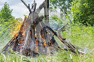 A burning bonfire with bright flame tongues close-up.