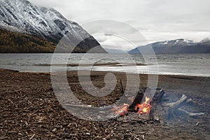 A burning bonfire on the shore of Lake Teletskoye. Altai Republic