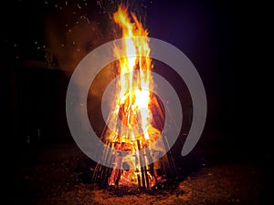 Burning bonfire with sparks on a dark background