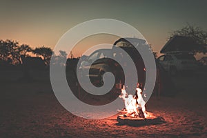 Burning camp fire at dusk in camping site, Botswana, Africa. Summer adventures and exploration in the african National Parks. Sele