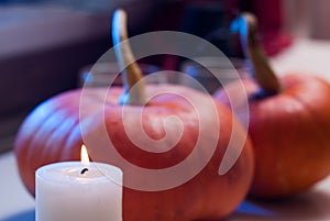 Burning candle on the background pumpkins,