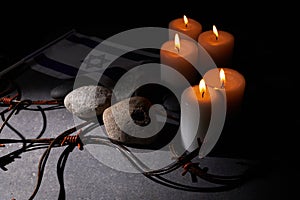 Burning candle, Barbed wire, flag of Israel on dark background. Holocaust memory day