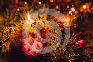 Burning candle and Christmas decoration. Elegant low-key shot with festive mood