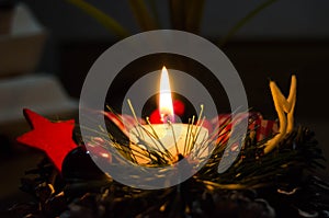 Burning candle and Christmas decoration over snow and wooden background, elegant shot with festive mood