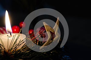 Burning candle and Christmas decoration over snow and wooden background, elegant shot with festive mood