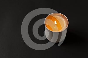 A burning candle on a dark background. Close-up. Selective focus