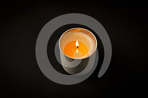 A burning candle on a dark background. Close-up. Selective focus