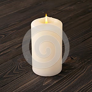 Burning candle on a dark wooden table