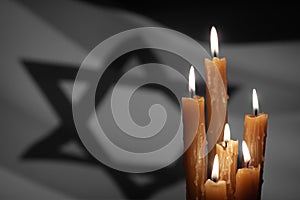 Burning candle on Israel flag background.