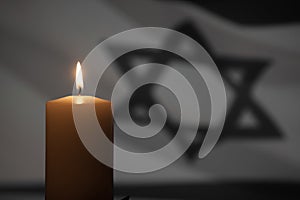 Burning candle on Israel flag background.