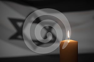 Burning candle on Israel flag background.