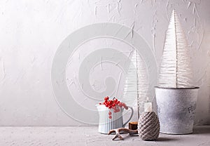 Burning  candle, jug with winter berries, horne, white holiday trees