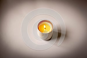 A burning candle on a light background. Close-up. Selective focus