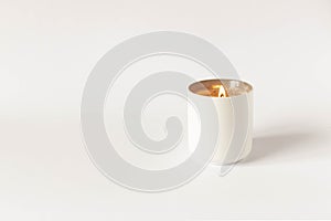 A burning candle on a light background. Close-up. Selective focus
