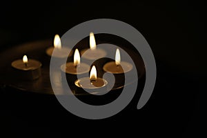 Burning candle on the dark blackground