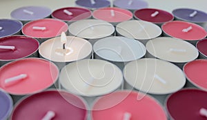 Burning candle among multicolored unlit candles