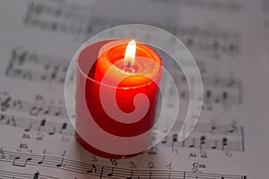 Burning candle on a music sheet