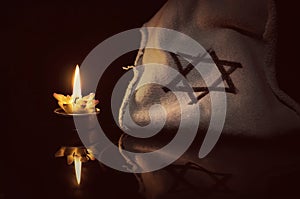 A burning candle next to the star of David