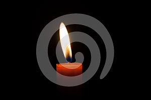 A burning candle at night. Symbol of life, love and light, protection and warmth. Candle flame glowing on a dark background.