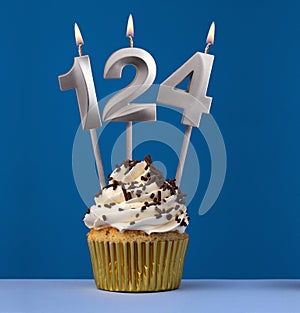 Burning candle number 124 - Birthday card with cupcake on blue Background