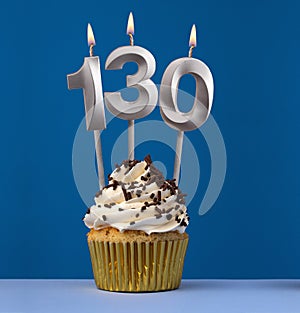 Burning candle number 130 - Birthday card with cupcake on blue Background
