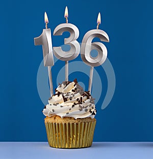 Burning candle number 136 - Birthday card with cupcake on blue Background