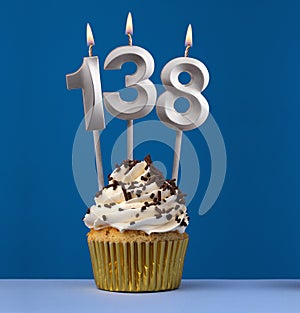 Burning candle number 138 - Birthday card with cupcake on blue Background