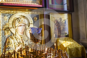 Burning candle in the Orthodox Church on the background of the icon of the mother of God