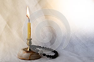 Burning candle and orthodox rosary. The concept of faith, prayer and the light of hope