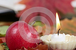 Burning candle with a red apple
