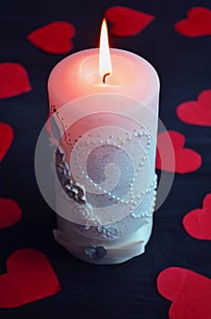 Burning candle, romantic atmosphere. On a wooden board. Valentine`s Day. Valentine