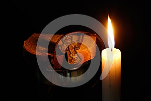 Burning candle, rood, glass with water and breads photo