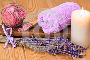 burning candle, towel and sea salt with lavender close-up objects for spa