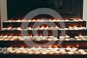 Burning candles on altar close-up in  church, lighting candle, mourning victims in terrorism attacks and revolutions, sadness