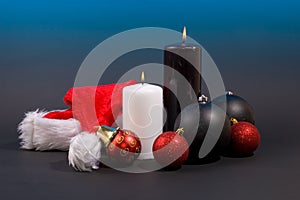 Burning candles with christmas balls and hat