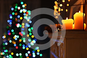 Burning candles on fireplace and Christmas tree