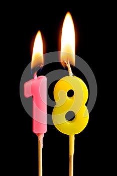 Burning candles in the form of 18 eighteen figures numbers, dates for cake isolated on black background. The concept of celebrat