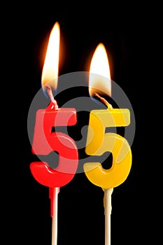 Burning candles in the form of 55 fifty five numbers, dates for cake isolated on black background. The concept of celebrating a