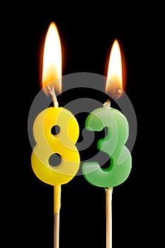 Burning candles in the form of 83 eighty three numbers, dates for cake isolated on black background. The concept of celebrating