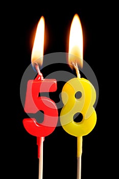 Burning candles in the form of 58 fifty eight numbers, dates for cake isolated on black background. The concept of celebrating a