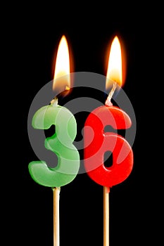 Burning candles in the form of 36 thirty six numbers, dates for cake isolated on black background. The concept of celebrating a