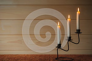 Burning candles glow in candlestick
