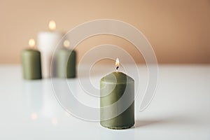 Burning candles in green and beige colors