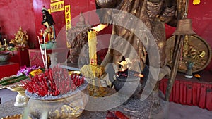 Burning candles and incense in a temple in Thailand.