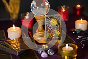 Burning candles and moon tarot card on table