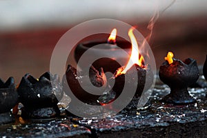 Burning candles and oil lamps in a buddhist temple in Thailand