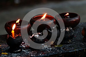 Burning candles and oil lamps in a buddhist temple in Thailand