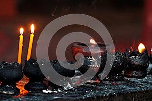 Burning candles and oil lamps in a buddhist temple in Thailand