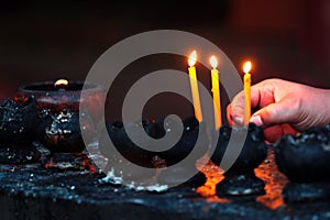 Burning candles and oil lamps in a buddhist temple in Thailand